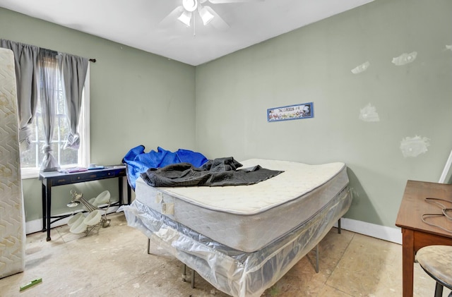 bedroom with ceiling fan, baseboards, and a baseboard radiator