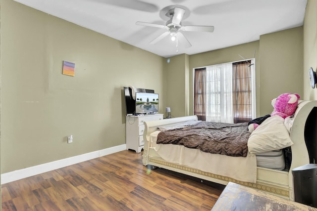 bedroom with ceiling fan, baseboards, and wood finished floors