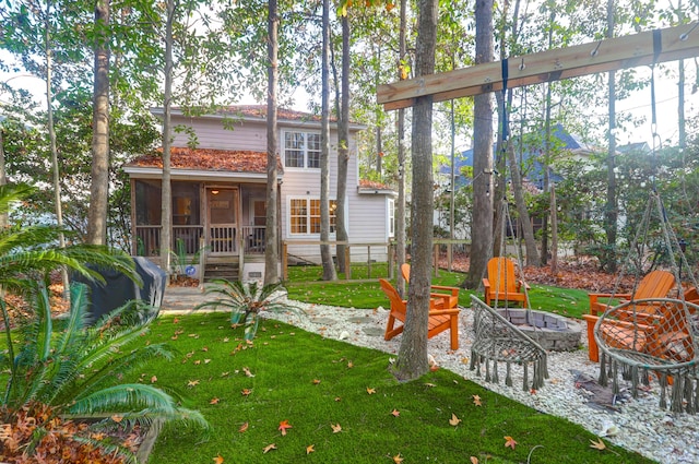 view of yard featuring an outdoor fire pit and a sunroom