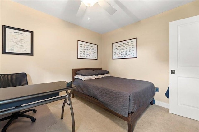 bedroom with a ceiling fan, light carpet, and baseboards