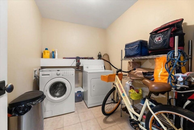 clothes washing area with laundry area, independent washer and dryer, and light tile patterned floors