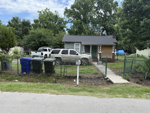1902 Clifton St, North Charleston, SC 29406 - bungalow featuring covered porch, a fenced front yard, a gate, a chimney, and a shingled roof