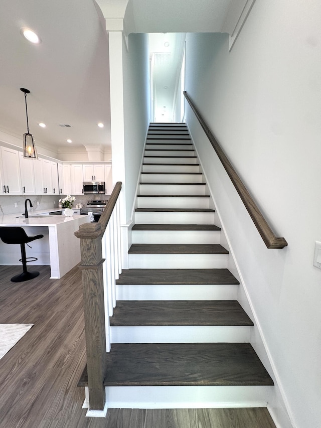 stairway featuring recessed lighting, baseboards, and wood finished floors