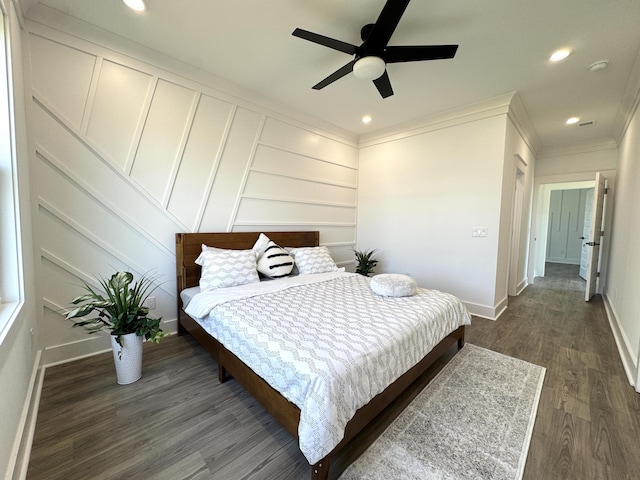 bedroom featuring dark wood-style floors, baseboards, recessed lighting, crown molding, and a decorative wall