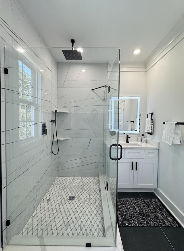 full bath featuring tile patterned floors, a stall shower, vanity, and baseboards