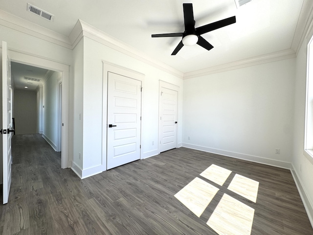 unfurnished bedroom featuring visible vents, ornamental molding, dark wood-style floors, baseboards, and ceiling fan