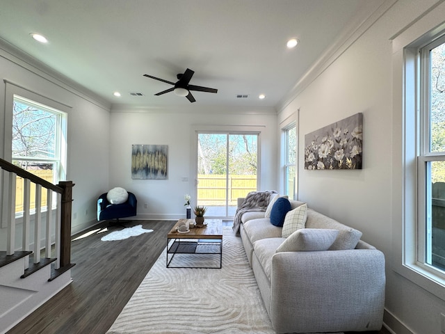 living area with visible vents, dark wood-type flooring, stairway, crown molding, and baseboards