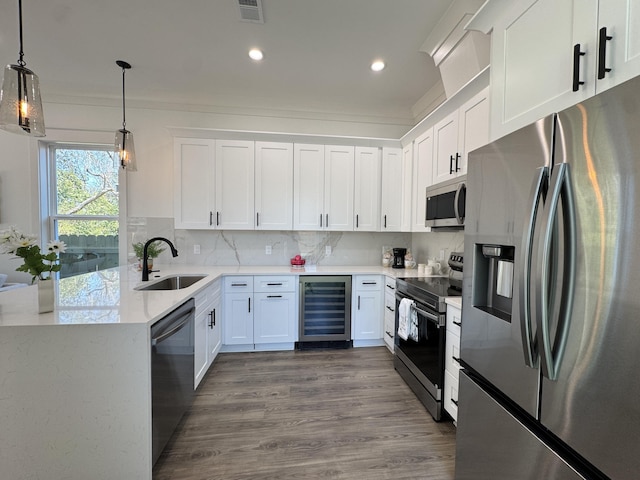 kitchen with visible vents, beverage cooler, decorative backsplash, stainless steel appliances, and a sink