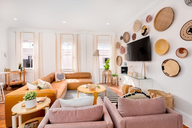 living room with hardwood / wood-style flooring, crown molding, and a wealth of natural light