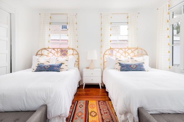 bedroom with dark wood-type flooring and multiple windows