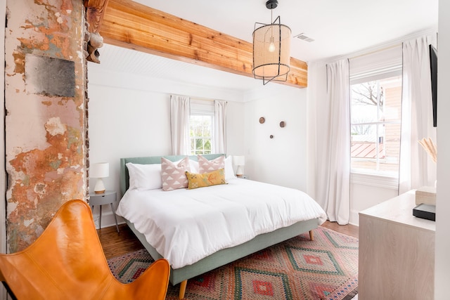 bedroom featuring beam ceiling and hardwood / wood-style flooring