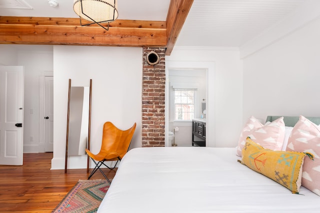 bedroom featuring hardwood / wood-style floors, connected bathroom, and crown molding