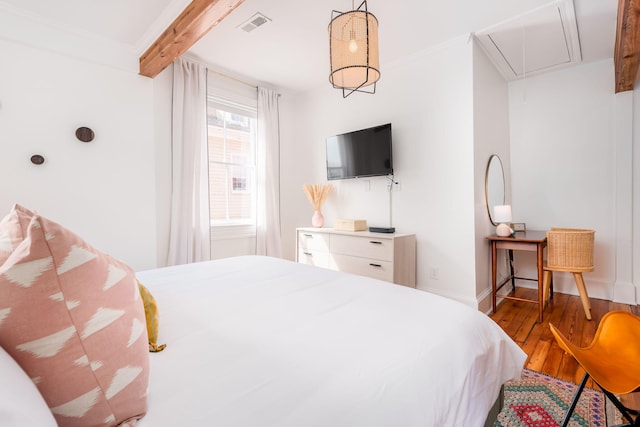 bedroom with beamed ceiling and hardwood / wood-style floors