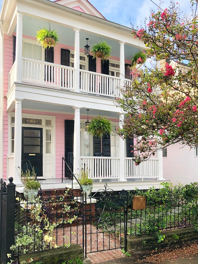 neoclassical / greek revival house with a balcony and covered porch