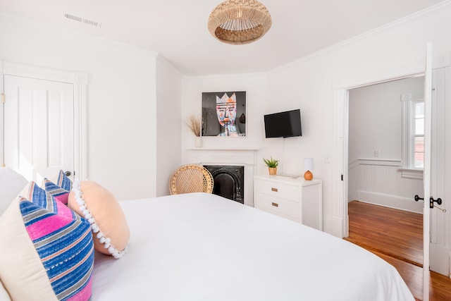 bedroom featuring hardwood / wood-style floors and crown molding