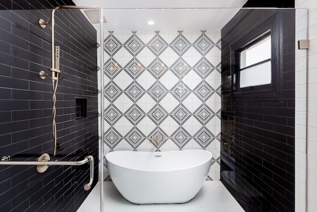 bathroom featuring a bath and tile walls