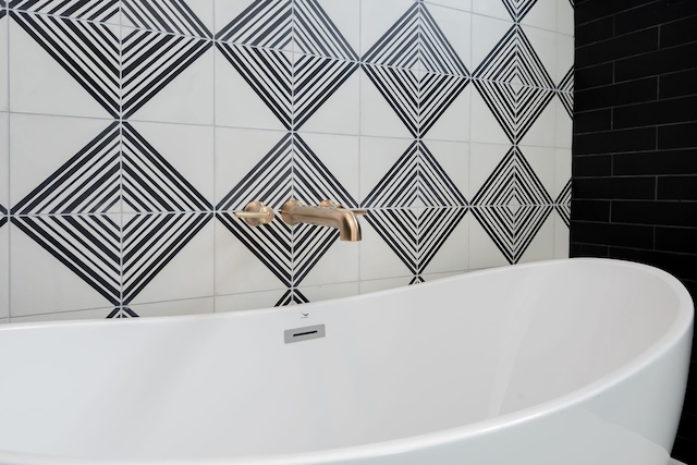 bathroom with a bathing tub and tile walls