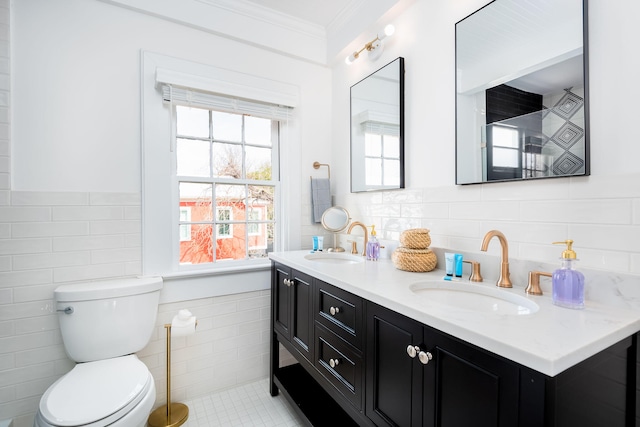 bathroom featuring tile patterned flooring, toilet, vanity, tile walls, and ornamental molding