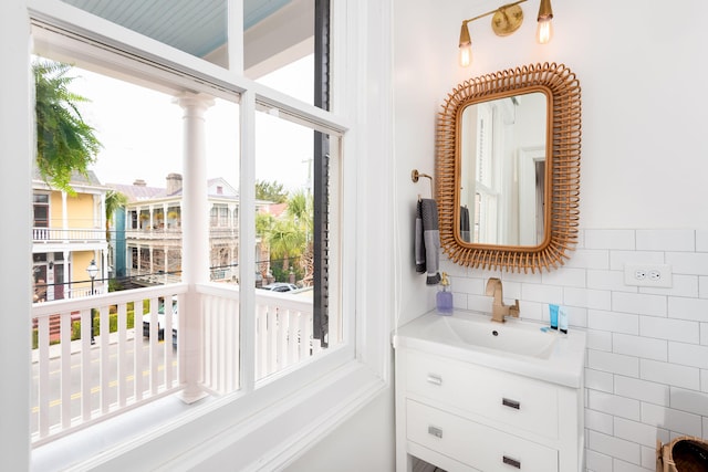 bathroom with vanity, plenty of natural light, and tile walls