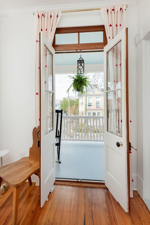 entryway with light hardwood / wood-style floors and ornamental molding