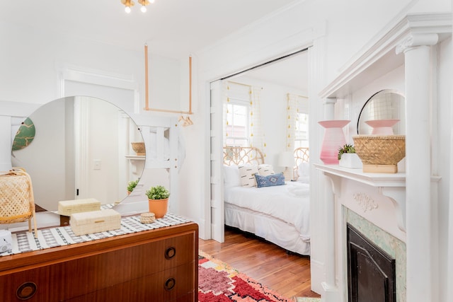 bedroom with light hardwood / wood-style floors and ornamental molding