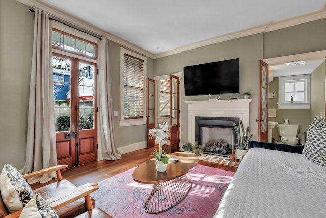 living room featuring wood-type flooring, plenty of natural light, and ornamental molding