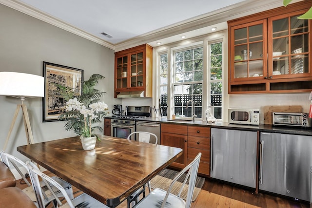 dining room with dark hardwood / wood-style floors, crown molding, and sink