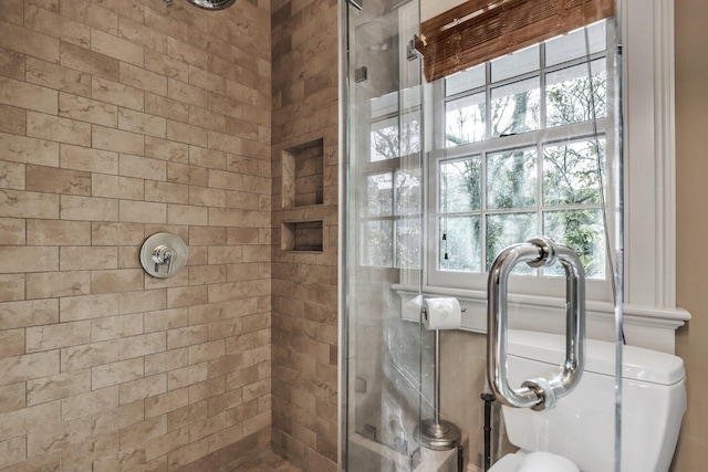 bathroom featuring an enclosed shower and toilet