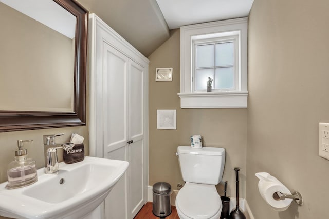 bathroom with toilet, sink, lofted ceiling, and hardwood / wood-style flooring