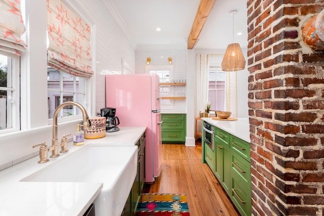 kitchen with sink, light hardwood / wood-style flooring, beamed ceiling, brick wall, and green cabinetry