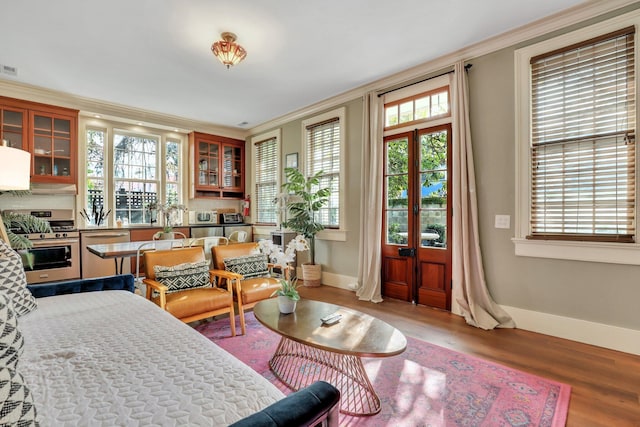 interior space with wood-type flooring, french doors, and ornamental molding