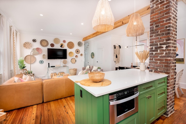 kitchen featuring stainless steel oven, light hardwood / wood-style floors, and green cabinetry