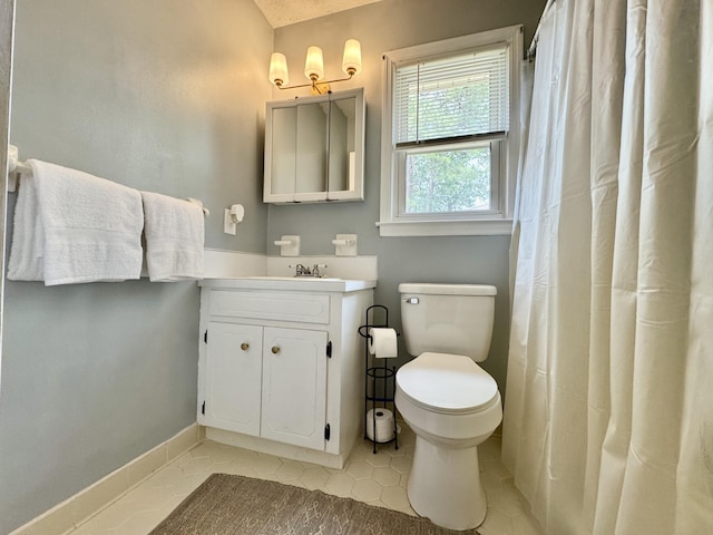 bathroom with toilet, baseboards, and vanity