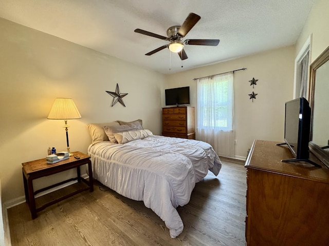 bedroom featuring baseboards, ceiling fan, and wood finished floors