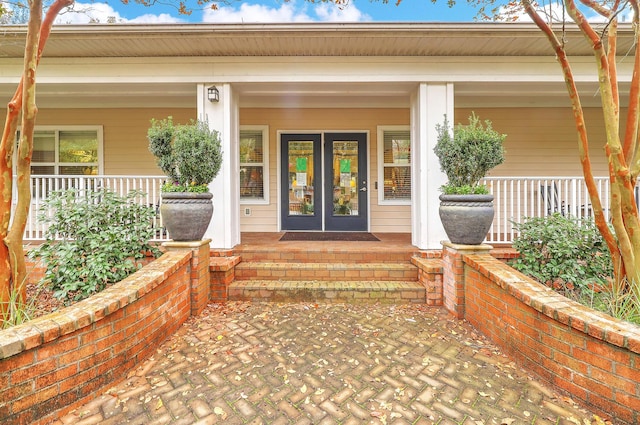 doorway to property with covered porch and french doors