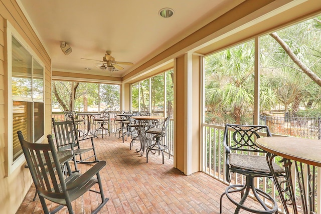 sunroom / solarium featuring a ceiling fan