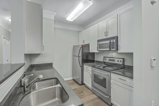 kitchen with light wood-type flooring, ornamental molding, a sink, white cabinetry, and appliances with stainless steel finishes