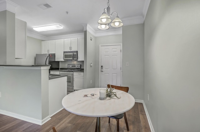 kitchen with dark wood-style floors, visible vents, stainless steel appliances, crown molding, and dark countertops