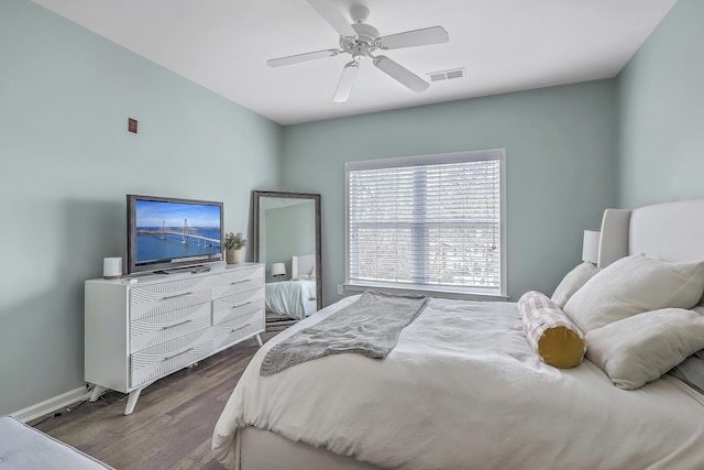 bedroom with a ceiling fan, visible vents, wood finished floors, and baseboards