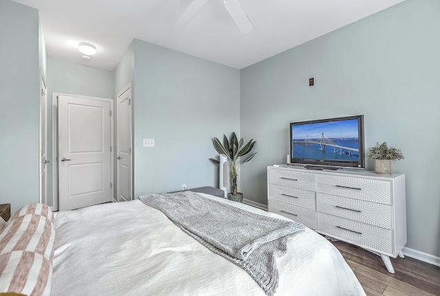 bedroom with a ceiling fan, wood finished floors, and baseboards