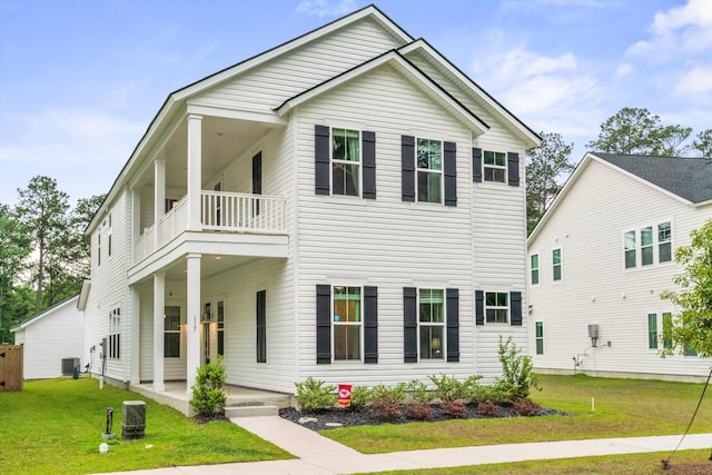 view of front of home featuring a balcony, a front lawn, central AC unit, and covered porch