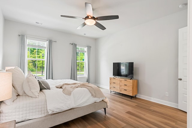 bedroom with wood finished floors, baseboards, and a ceiling fan