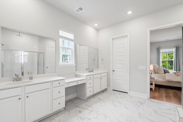 ensuite bathroom featuring a shower stall, two vanities, recessed lighting, marble finish flooring, and baseboards