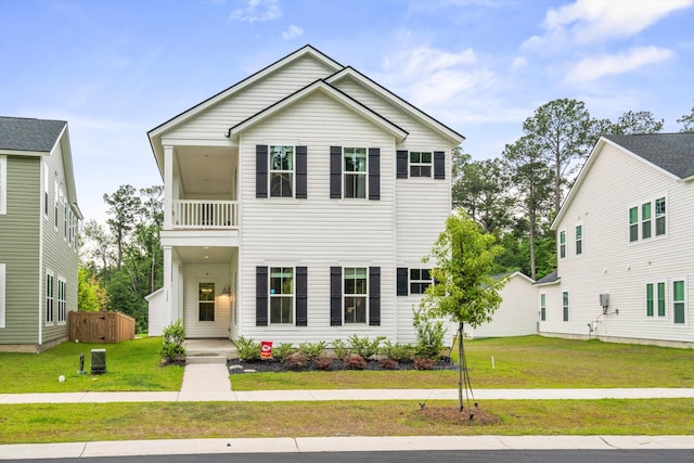 view of front of property featuring a balcony and a front yard