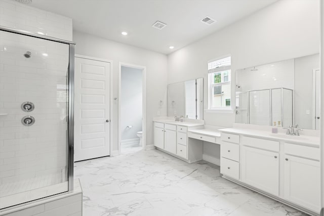 bathroom with marble look tiles, a stall shower, toilet, two vanities, and recessed lighting