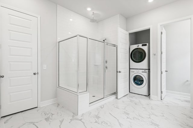 laundry area featuring stacked washer / dryer, light marble finish flooring, baseboards, and recessed lighting