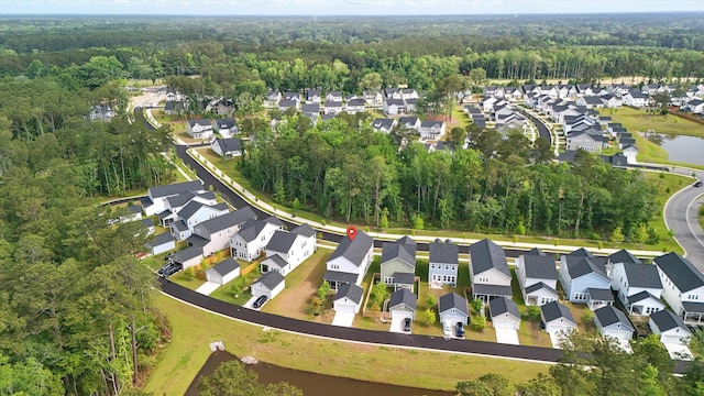 aerial view of property's location with a heavily wooded area and nearby suburban area