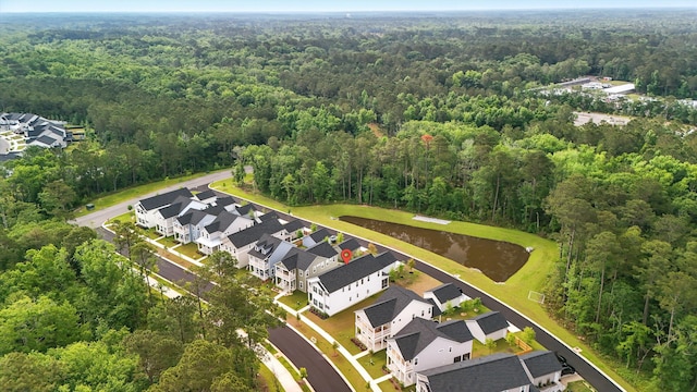 aerial overview of property's location with a forest, nearby suburban area, and a large body of water