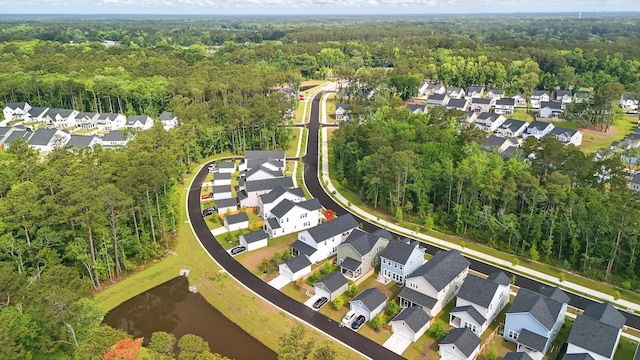 aerial overview of property's location featuring a heavily wooded area, nearby suburban area, and a large body of water