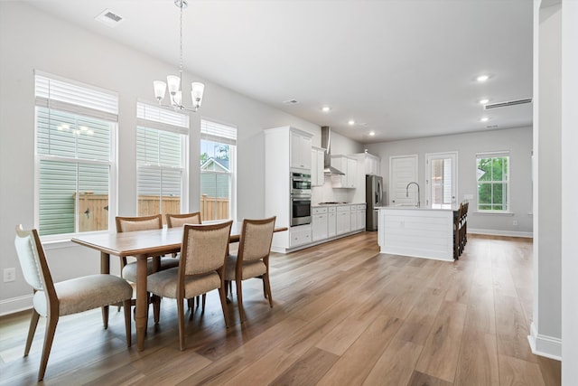 dining area featuring a chandelier, light wood-style floors, plenty of natural light, baseboards, and recessed lighting